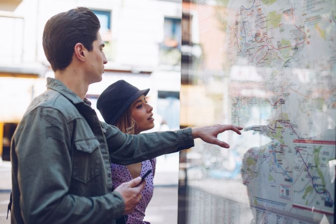 Young couple looking at map in street