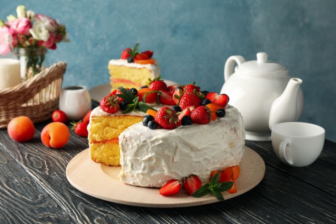 Composition with delicious berry cream cake on wooden table. Tasty dessert