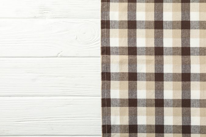 Checkered tablecloth on wooden background, space for text