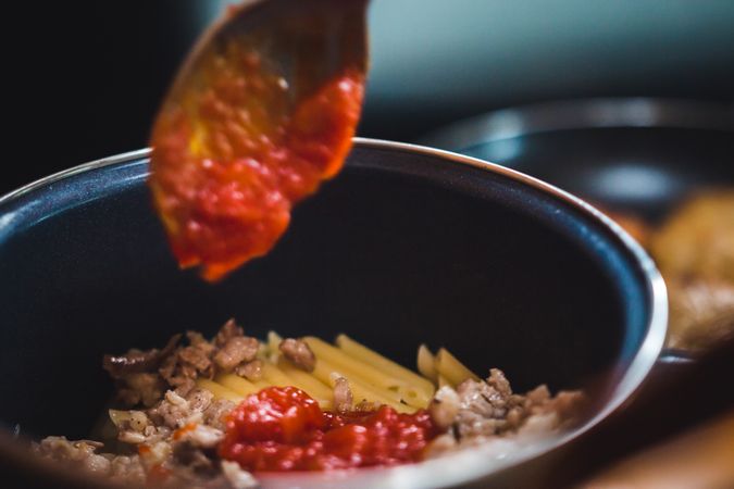 Hand cooking pasta in a saucepan