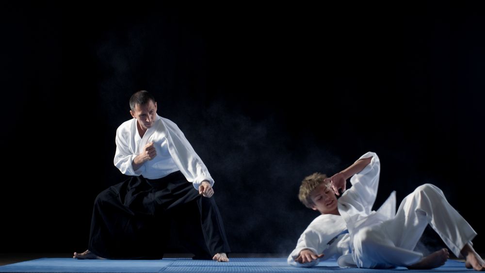 Martial Arts Aikido Master Wearing Hakamas Teaches His Young Student How to Defend Himself Against an Attack.