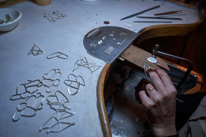 Faceless artisan working with jewelry on finagel