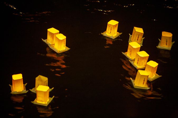 Lit lantern floating on water at night in Thailand