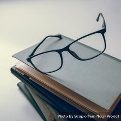 Framed eyeglasses on stack of books 0vKVo5