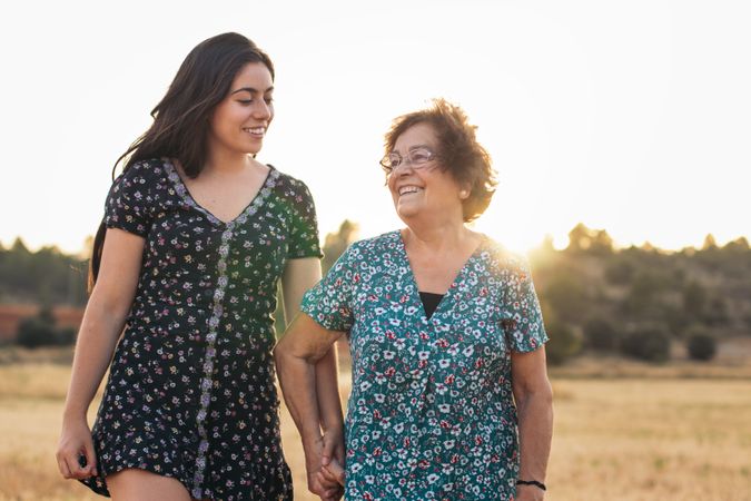 Grandmother and granddaughter in a field of sunflowers.