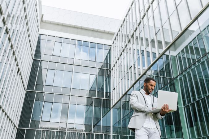 Black man holding laptop on street
