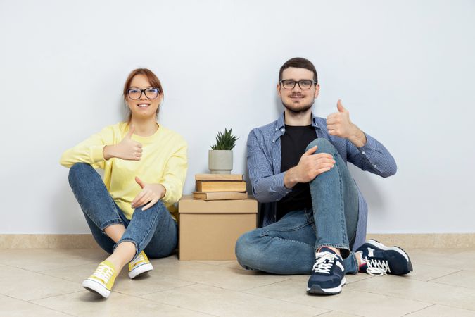 Moving concept, couple man and woman with boxes in apartment.