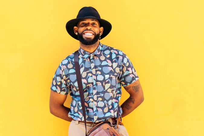 Stylish Black man outdoors over yellow background