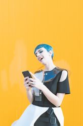 Cheerful futuristic woman texting on smartphone