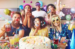 Confetti and balloons in the air as friends celebrate a birthday