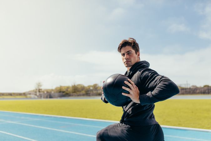 Athlete working out with a medicine ball on the track