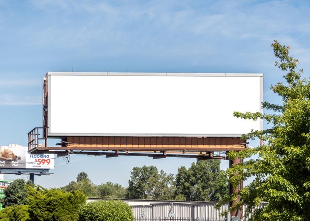 Digital billboard mockup next to road on nice day