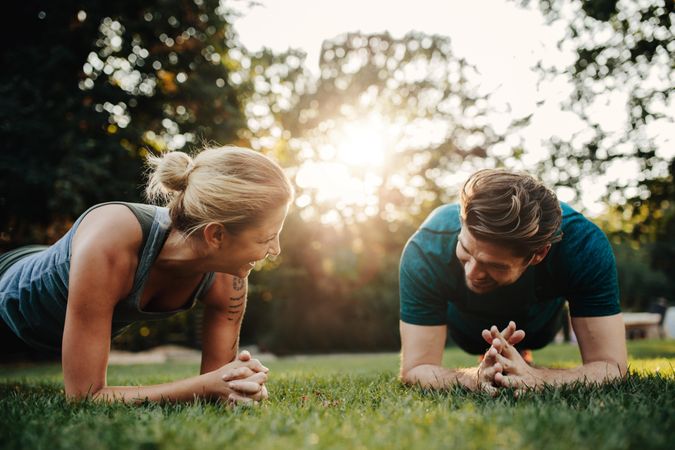 Fit couple doing planks in the park