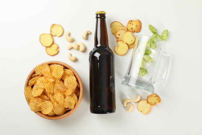 Concept of beer and snacks on light background