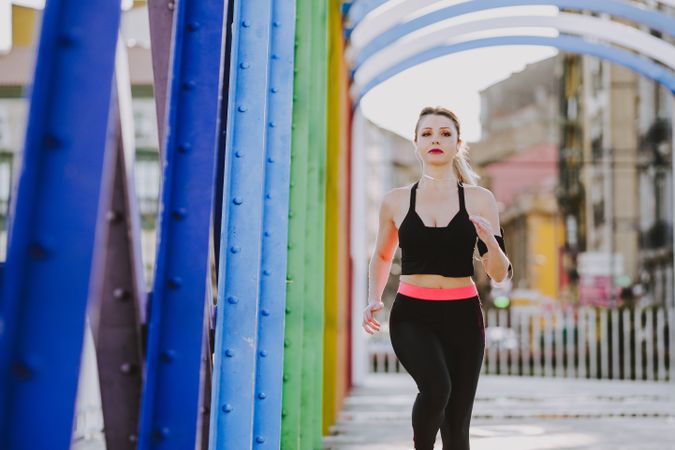 Woman with earphones running on street