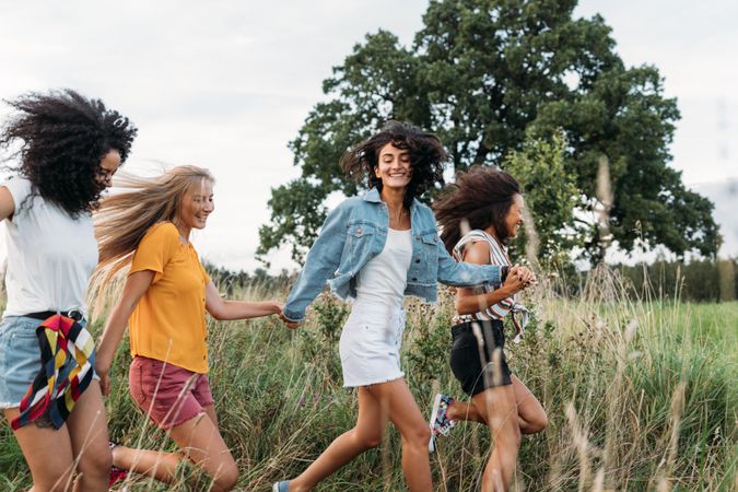 Female friends having fun in long grass outside