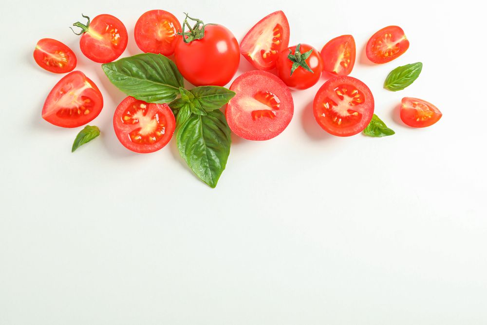 Flat lay composition with fresh cherry tomatoes and basil on plain background, space for text. Ripe vegetables