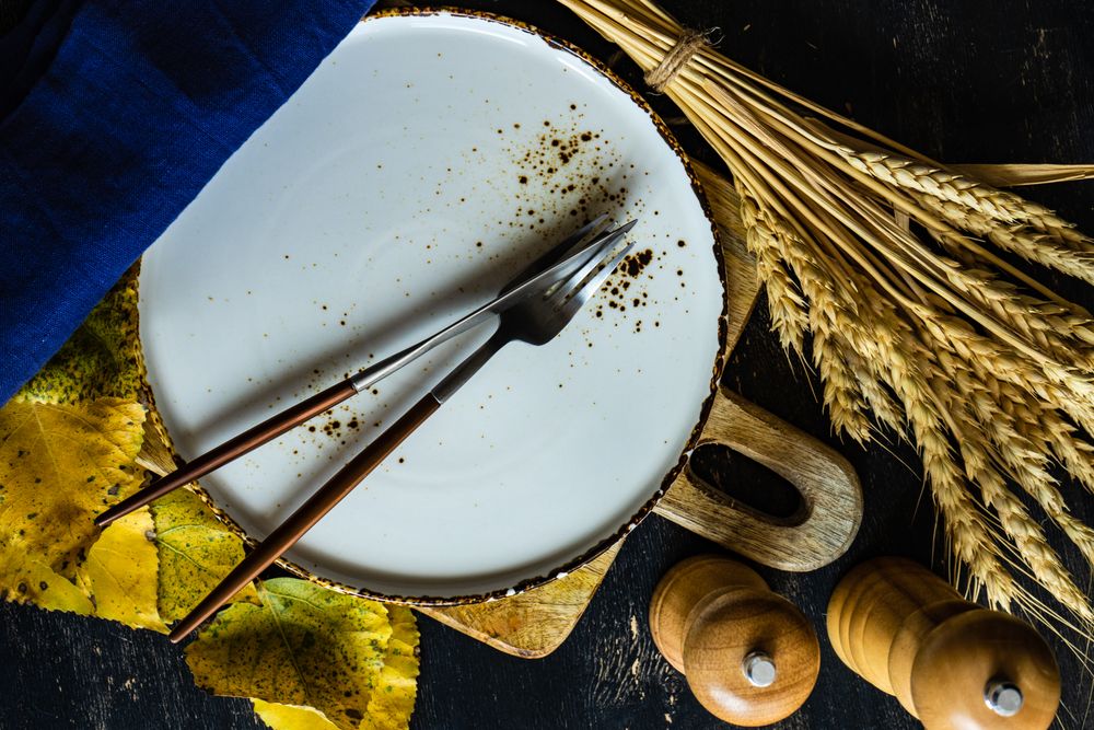 Top view of grey tableware with cutlery and autumnal decor