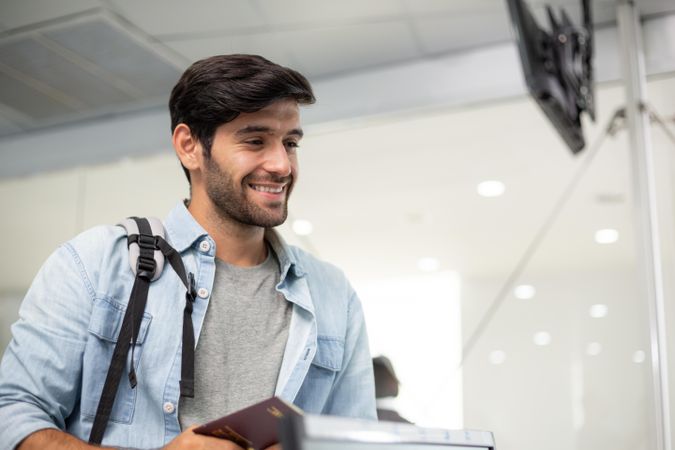 Happy male with passport awaiting check in at airport