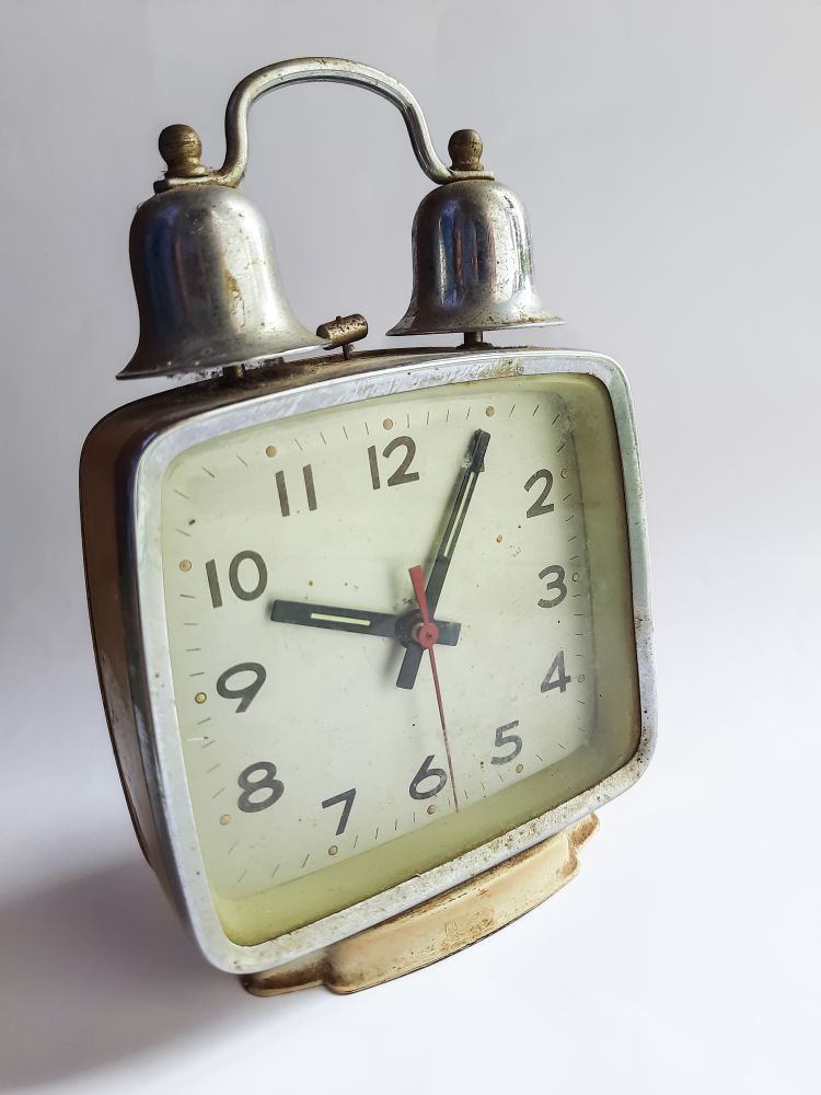 Old rusty and vintage alarm clock on a plain background