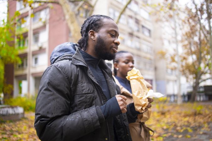 Fall Scene: Friends Holding Takeaway Food in Rainy Weather