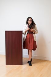 Woman at podium holding microphone and smiling while giving a talk