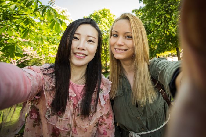 Multiracial friends taking selfie in park