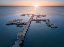 Overwater pier of resort at sunset