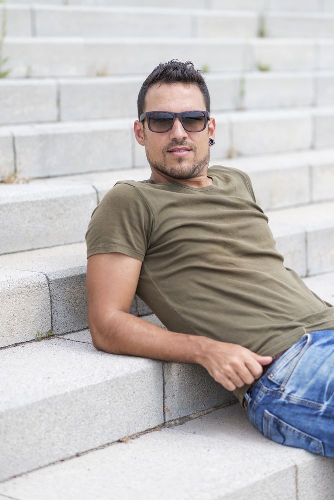 Man reclining on outdoor stairs, vertical