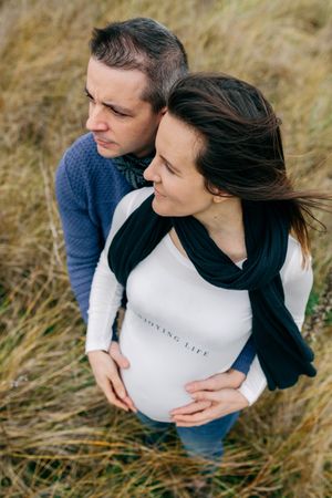 Pregnant couple hugging and holding belly