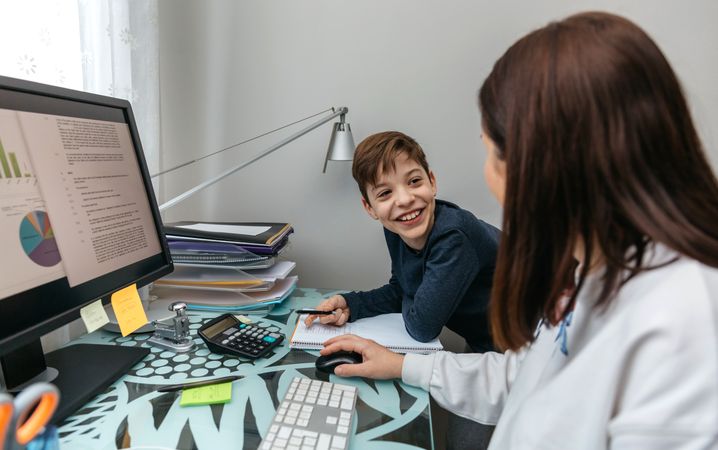 Woman teleworking at home talking with her son