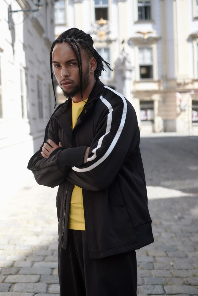 Black male standing with arms crossed
