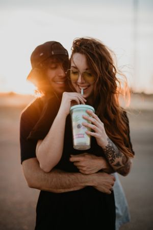 Hipster couple bonding on field in sunlight
