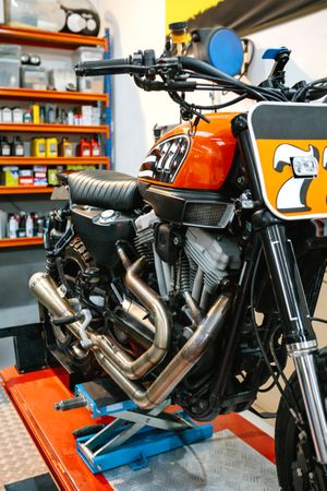 Close up of black and red custom motorbike on empty workshop over platform