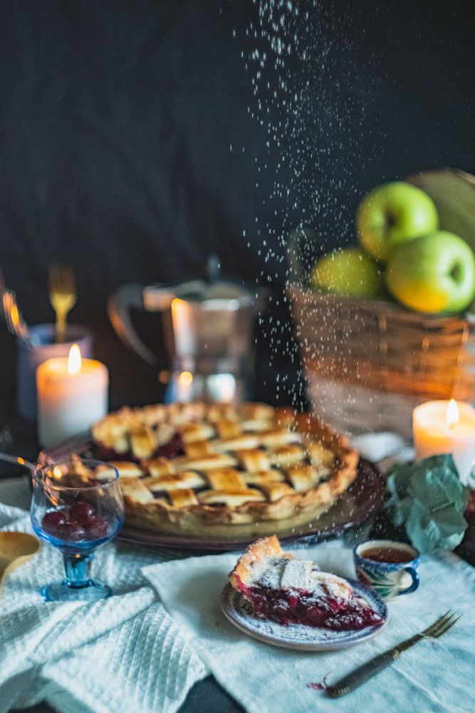 Powdered sugar dusting falling on top of cherry pie slice