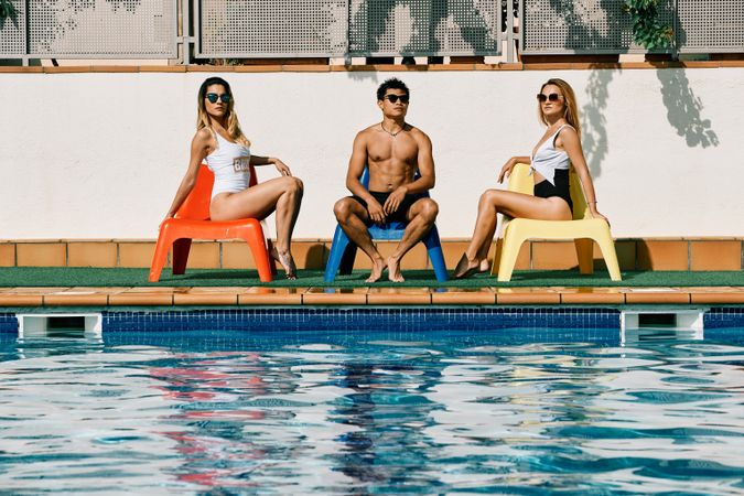 a group of young models by the pool with sunglasses