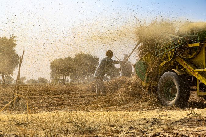 Farmer standing beside a vehicle in the field