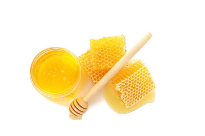 Pieces of honeycomb, glass jar and dipper isolated on plain background