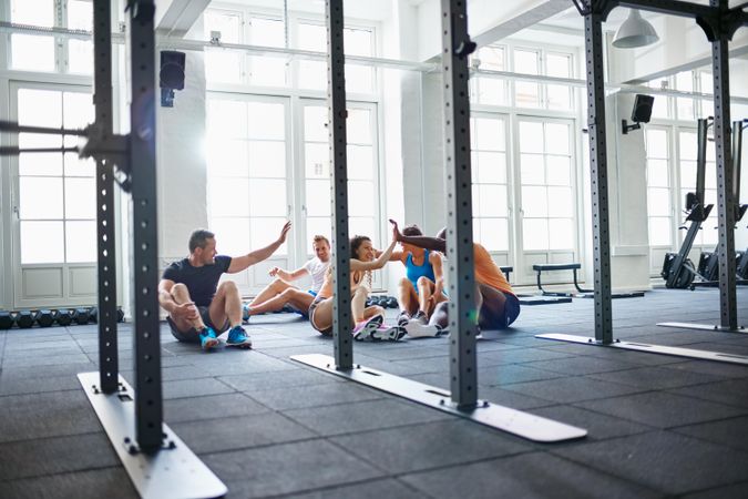 Group of people sitting and congratulating themselves after a workout