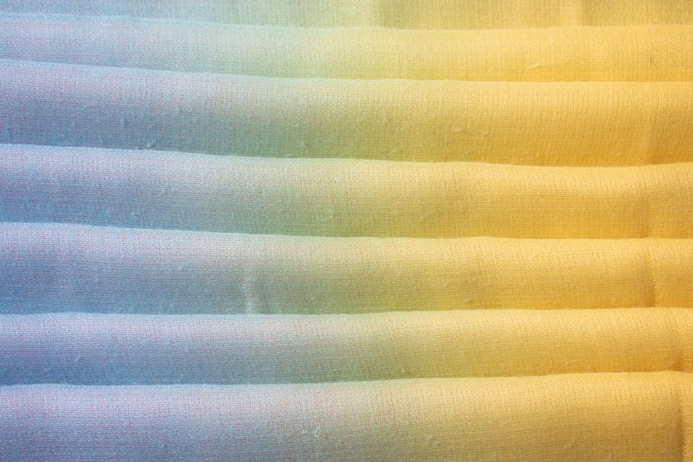 Gradient colorful folded fabric background texture. blue yellow and green.
