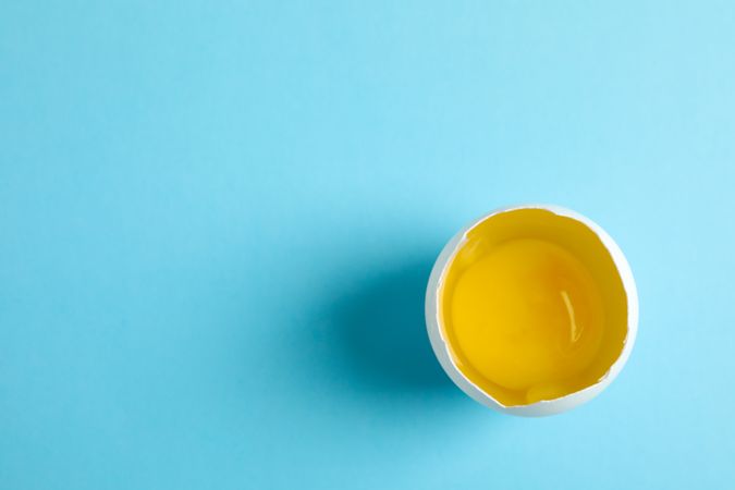 Half with yolk on color  background, space for text
