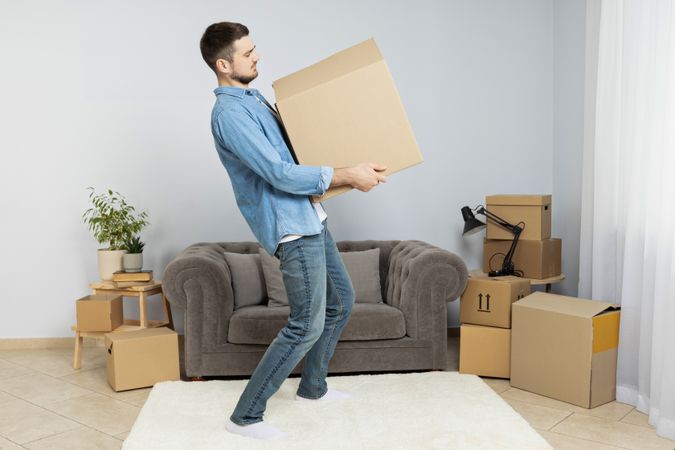 Moving concept, man with boxes in apartment.