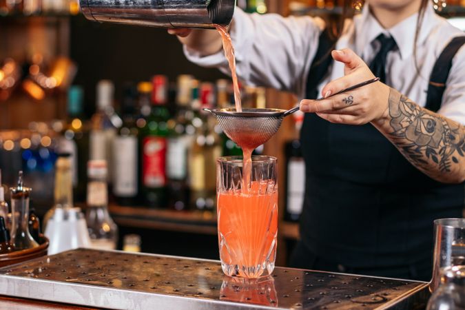 Female bartender preparing a cocktail in a traditional cocktail bar