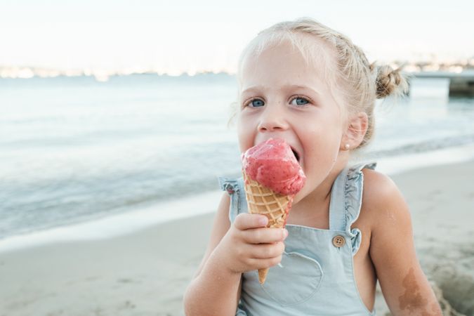 Happy girl enjoying ice cream on beach