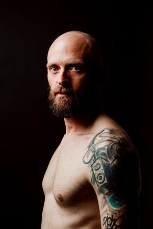 Young shirtless bearded guy with tattoos