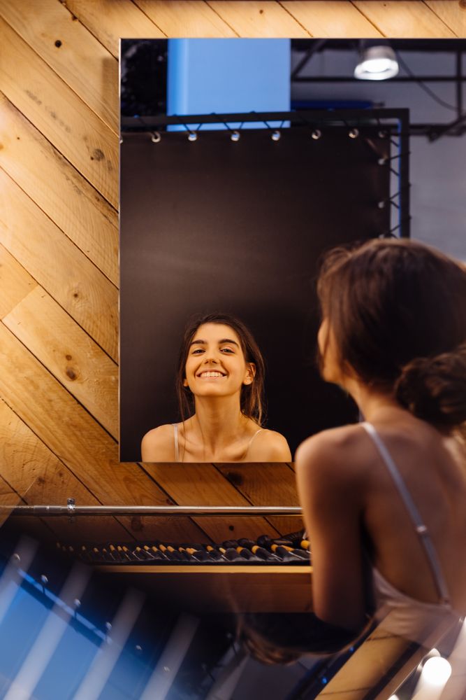 Cheerful brunette model looking in mirror