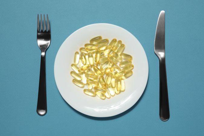 Omega pills in a bowl with a knife and fork