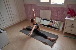 Child doing splits and spreading arms at home