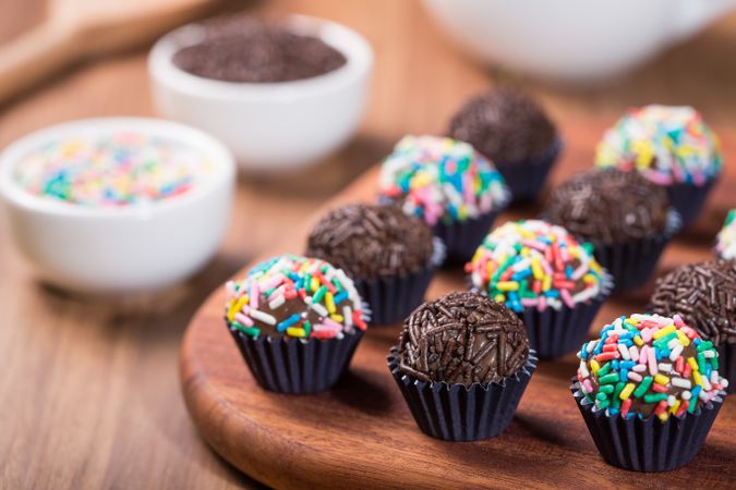 Chocolate truffles with sprinkles presented on a wooden board