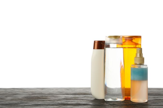 Blank cosmetics bottles on wooden table isolated on light background